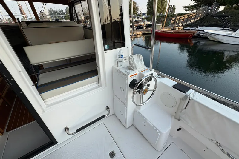 Slide: The Image of 2018 Cutwater C-30 CB boat interior with steering wheel and seating, docked by the water. - 61
