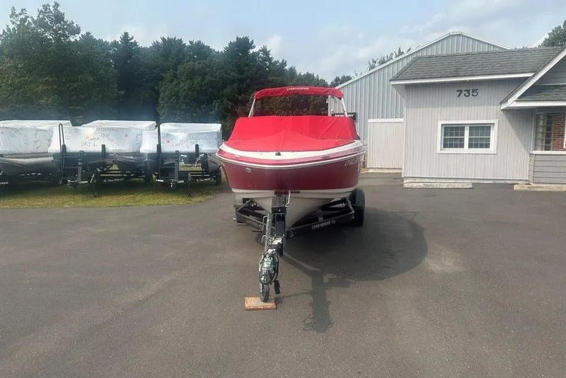 Slide: The Image of 2015 Chaparral Vortex 203 VR boat with red cover on trailer, parked outside a building. - 22