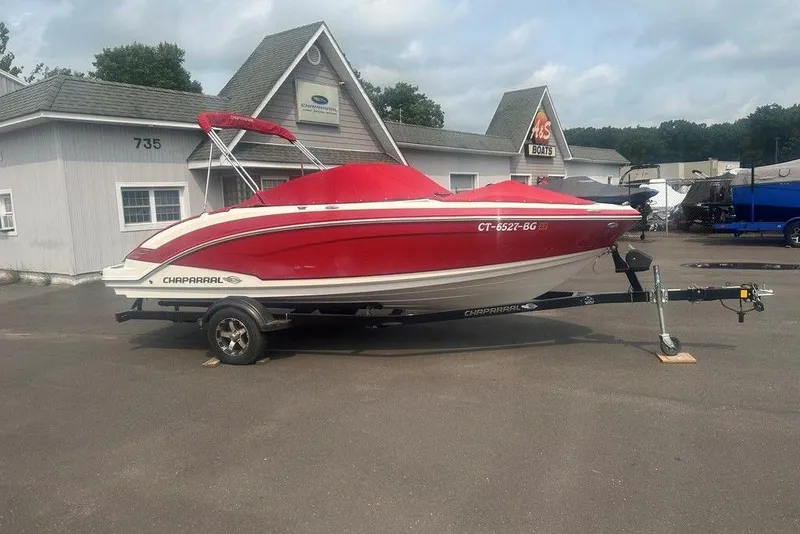Slide: The Image of 2015 Chaparral Vortex 203 VR boat in red, parked on a trailer outside a dealership. - 25