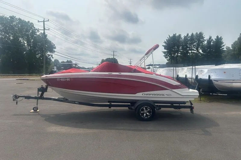 Slide: The Image of 2015 Chaparral Vortex 203 VR boat with red cover on trailer, parked outdoors. - 27