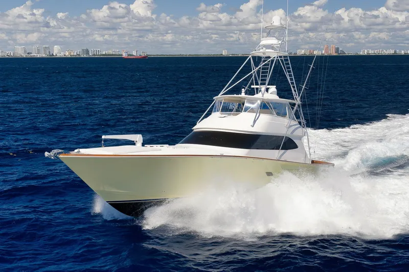 Slide: The Image of 2010 Viking 82 Convertible yacht cruising on open ocean with city skyline in background. - 3