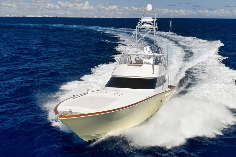 Slide: The Image of 2010 Viking 82 Convertible yacht cruising on open ocean with city skyline in background. - 6