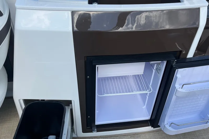 Slide: The Image of Open refrigerator on 2015 Monterey 268 SSC boat, showcasing interior storage space. - 12