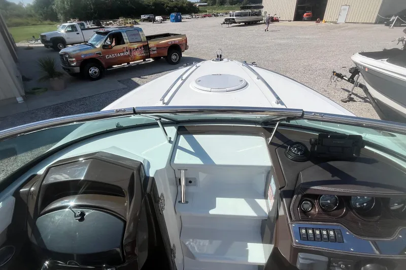 Slide: The Image of 2015 Monterey 268 SSC boat interior with dashboard, parked near a truck and building. - 14
