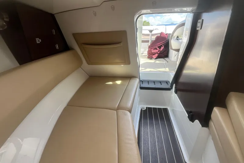 Slide: The Image of Interior of a 2015 Monterey 268 SSC boat with beige seating and open cabin door. - 16
