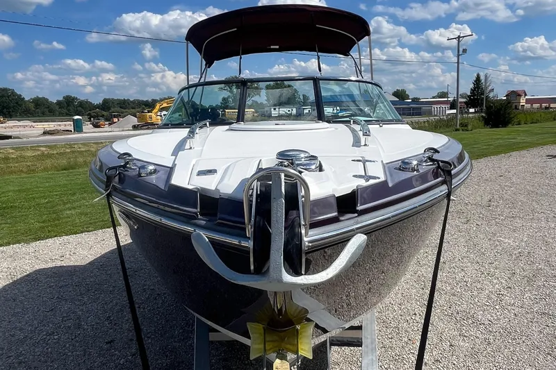 Slide: The Image of 2015 Monterey 268 SSC boat on display, front view, sunny day, gravel lot. - 2