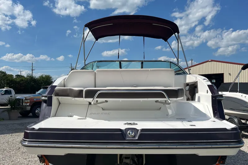 Slide: The Image of 2015 Monterey 268 SSC boat with canopy, parked outdoors under a blue sky. - 3