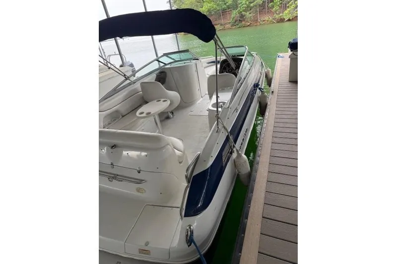 Slide: The Image of 2003 Crownline 239 DB boat docked, featuring spacious seating and sleek design. - 7