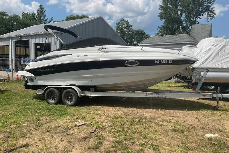 The Image of 2015 Crownline 236 SC boat on trailer, parked outdoors near metal building. - 0