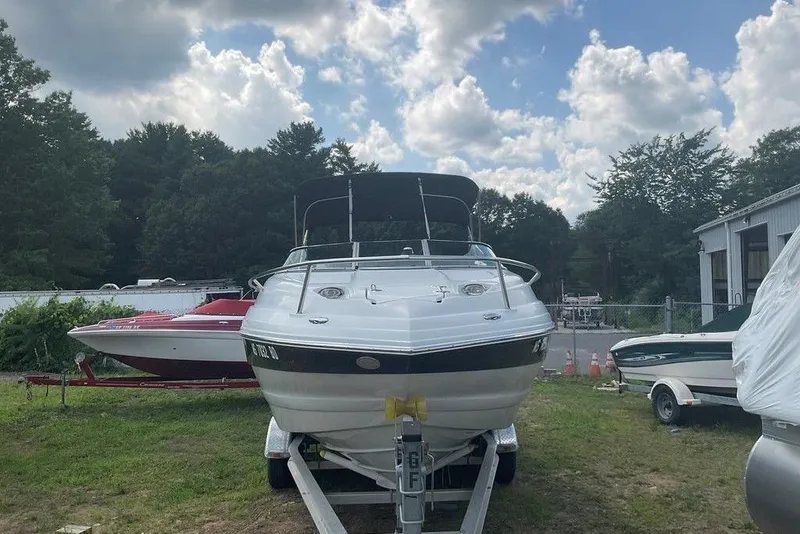 Slide: The Image of 2015 Crownline 236 SC boat on trailer, parked outdoors under cloudy sky. - 1