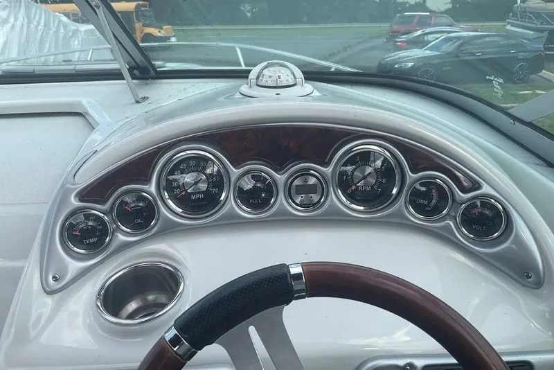 Slide: The Image of Dashboard of a 2015 Crownline 236 SC boat with gauges and steering wheel. - 10