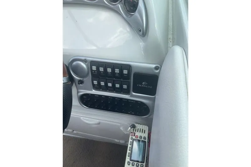 Slide: The Image of Control panel of 2015 Crownline 236 SC boat with switches and remote. - 11