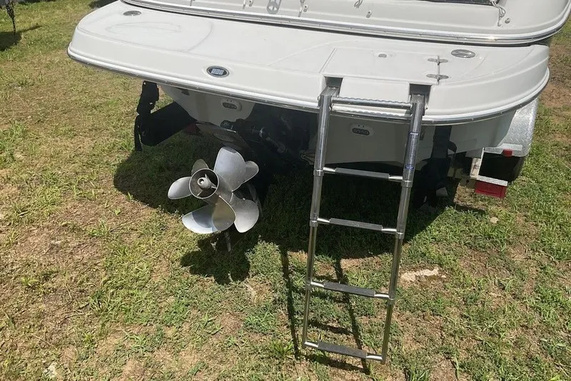 Slide: The Image of Rear view of 2015 Crownline 236 SC boat with ladder and propeller on grass. - 15