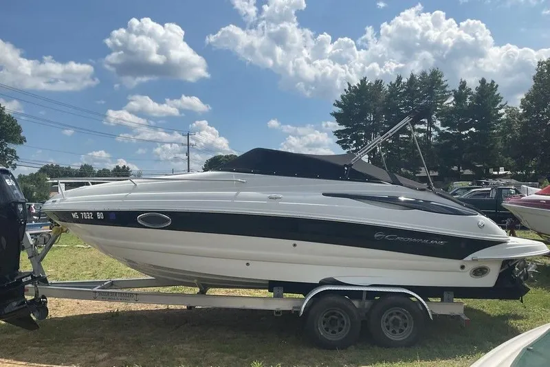 Slide: The Image of 2015 Crownline 236 SC boat on trailer under a partly cloudy sky. - 2