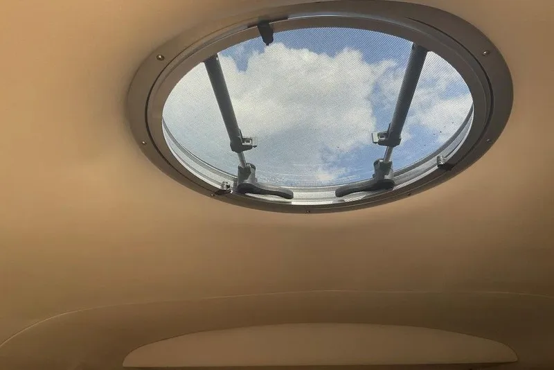 Slide: The Image of Circular hatch view from 2015 Crownline 236 SC boat, showing blue sky and clouds. - 24