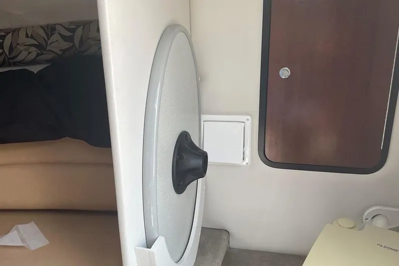 Slide: The Image of Interior cabin of 2015 Crownline 236 SC boat, featuring a door and seating area. - 27
