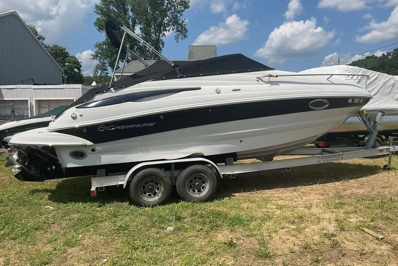 Slide: The Image of 2015 Crownline 236 SC boat on trailer, parked outdoors under a partly cloudy sky. - 3