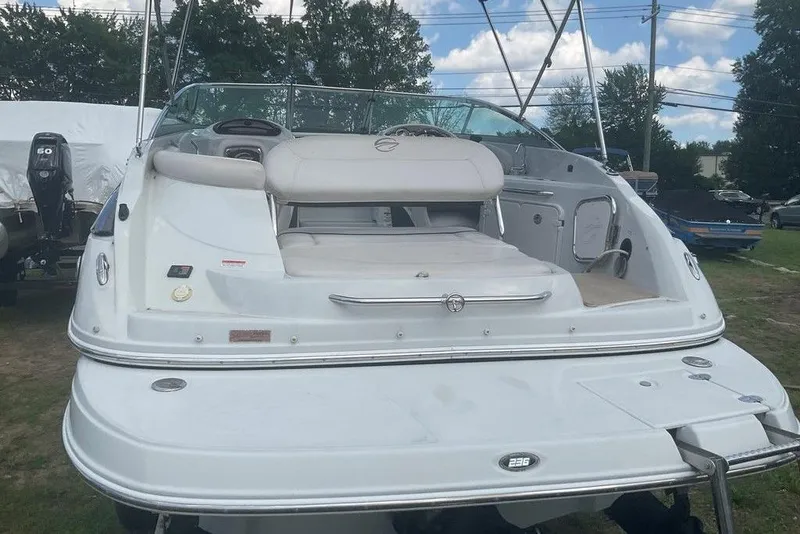 Slide: The Image of 2015 Crownline 236 SC boat, rear view, white exterior, parked outdoors. - 4