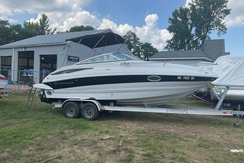 Slide: The Image of 2015 Crownline 236 SC boat on trailer near a garage, under a partly cloudy sky. - 5