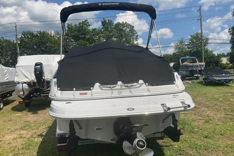 Slide: The Image of 2015 Crownline 236 SC boat with black cover, parked on grass under a cloudy sky. - 8