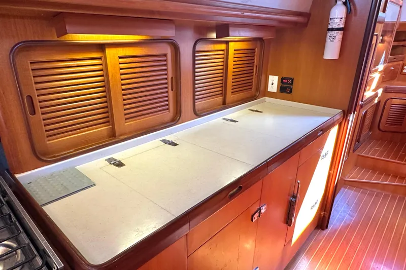 Slide: The Image of 2006 Passport 470 yacht interior with wooden cabinets and countertop in galley area. - 10