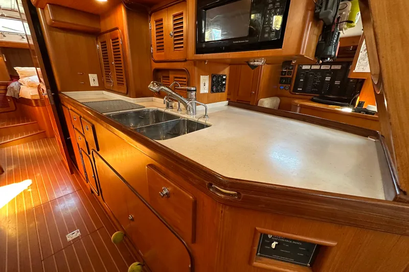 Slide: The Image of Luxurious wooden interior of a 2006 Passport 470 yacht kitchen with modern amenities. - 12