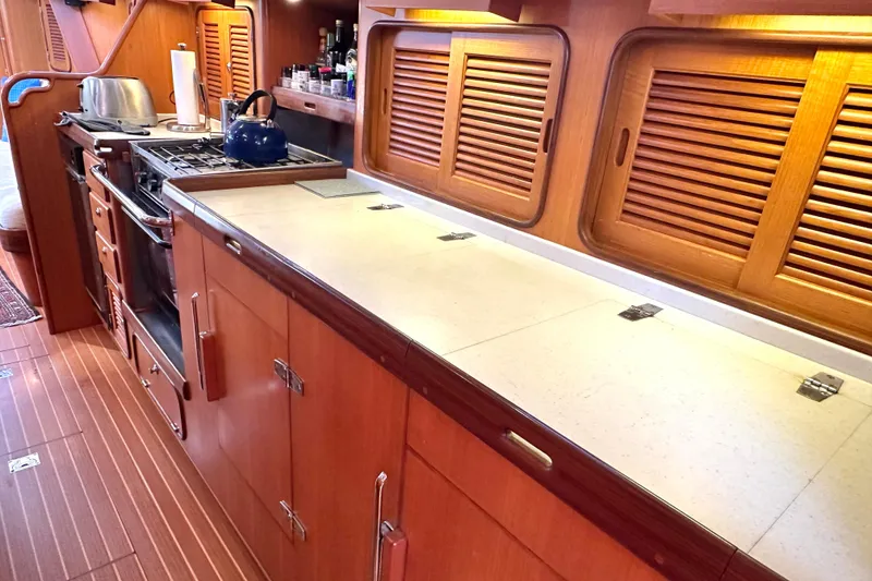 Slide: The Image of Wooden galley kitchen in 2006 Passport 470 yacht with stove and storage cabinets. - 15