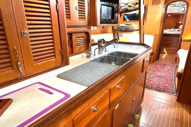 Slide: The Image of Luxurious wooden interior of a 2006 Passport 470 yacht kitchen with sink and cabinets. - 17