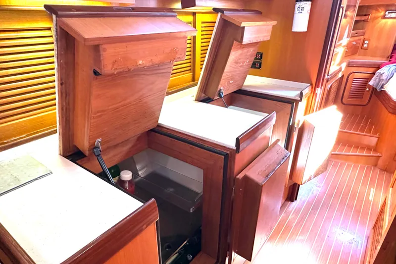 Slide: The Image of Interior of 2006 Passport 470 yacht with open wooden cabinets and sunlight streaming in. - 18
