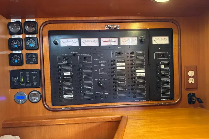 Slide: The Image of Electrical control panel on a 2006 Passport 470 yacht, featuring gauges and switches. - 22