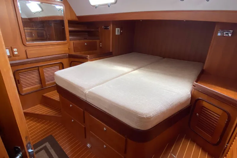 Slide: The Image of Luxurious 2006 Passport 470 yacht cabin with wooden interior and comfortable bedding. - 24