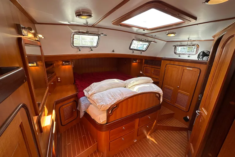 Slide: The Image of Luxurious 2006 Passport 470 yacht cabin with wooden interior and cozy bedding. - 25
