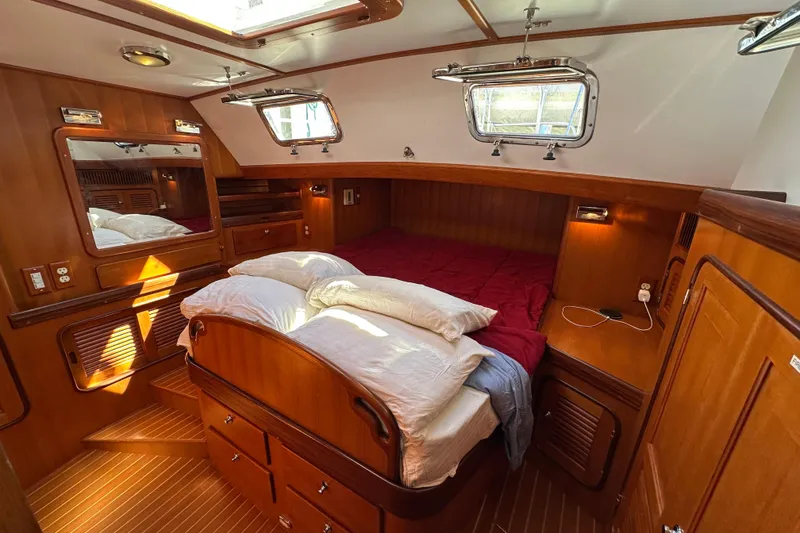 Slide: The Image of Luxurious 2006 Passport 470 yacht cabin with wooden interior and cozy bedding. - 26
