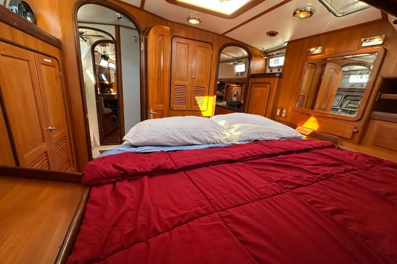 Slide: The Image of Luxurious 2006 Passport 470 yacht cabin with red bedding and wooden interior. - 27