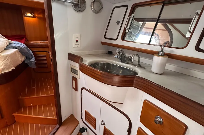 Slide: The Image of 2006 Passport 470 yacht interior with wooden cabinetry and compact bathroom sink area. - 29