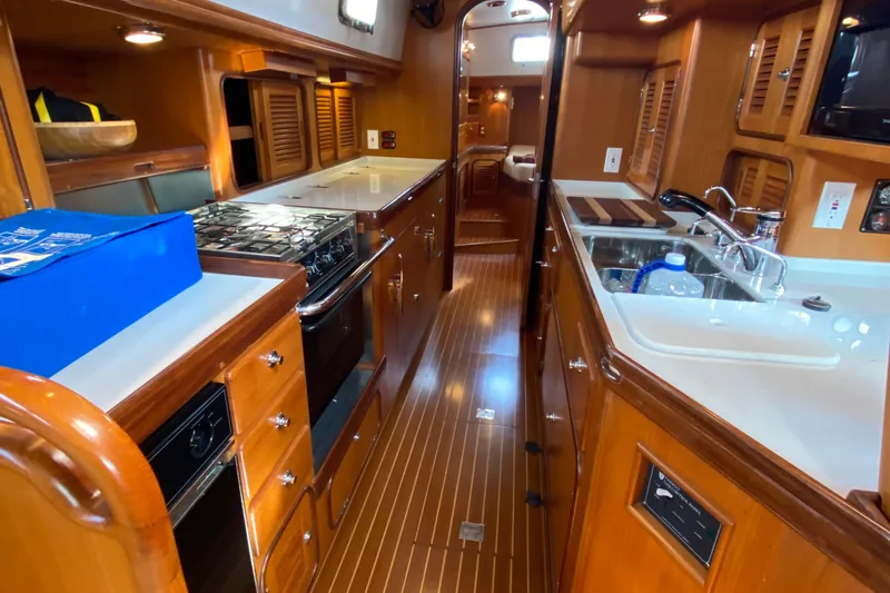 Slide: The Image of Luxurious 2006 Passport 470 yacht interior with modern kitchen and wooden cabinetry. - 3
