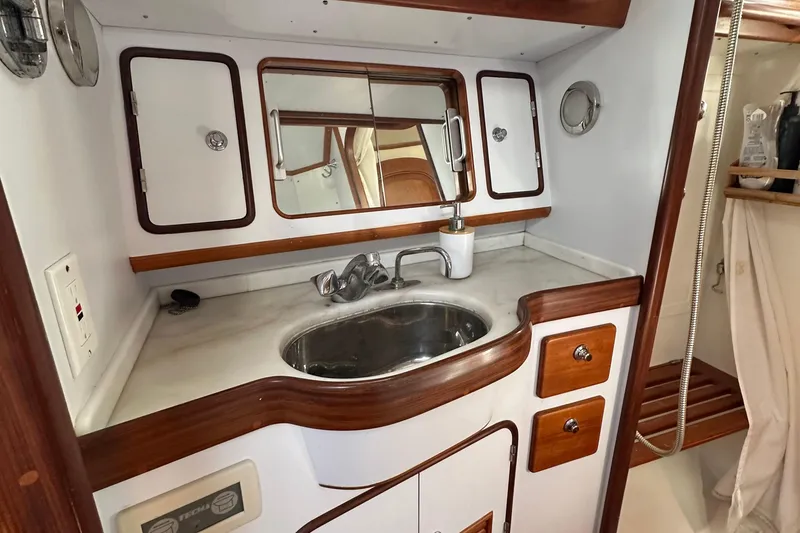Slide: The Image of Compact bathroom in 2006 Passport 470 yacht with sink, mirror, and wooden accents. - 30