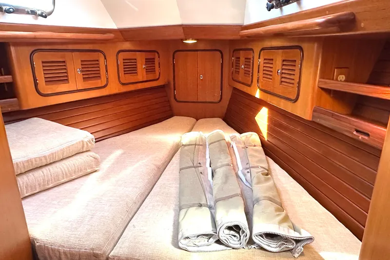 Slide: The Image of Cozy cabin interior of 2006 Passport 470 yacht with wooden paneling and beige cushions. - 34