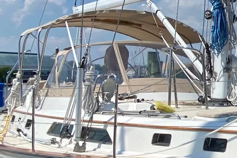 Slide: The Image of Sailboat Passport 470, 2006 model, docked with beige canopy and rigging. - 37