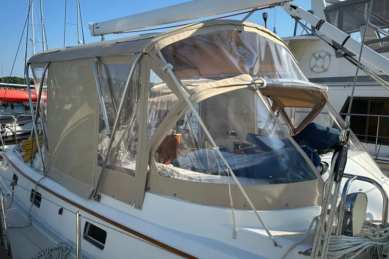 Slide: The Image of 2006 Passport 470 sailboat with beige canopy docked at marina. - 38
