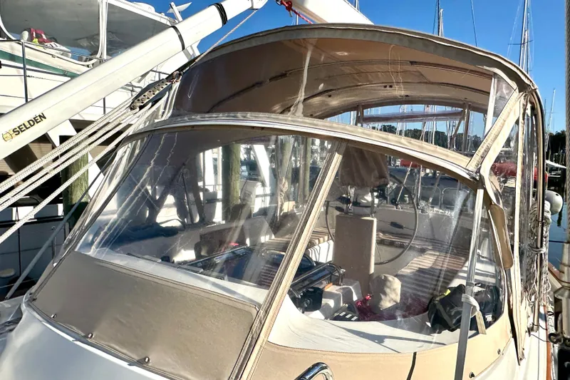 Slide: The Image of 2006 Passport 470 sailboat with beige canopy docked at marina. - 39
