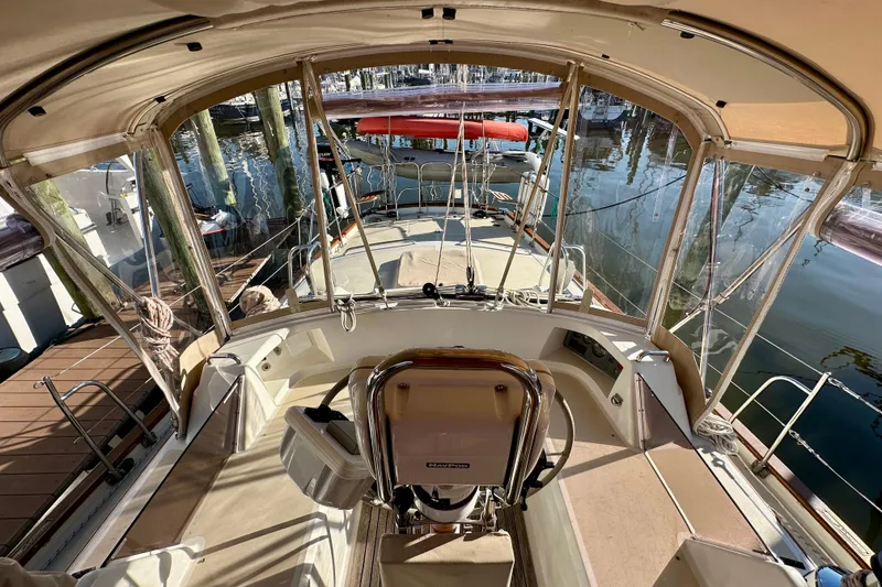 Slide: The Image of Interior view of a 2006 Passport 470 sailboat cockpit, featuring seating and helm. - 44