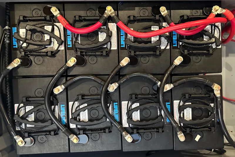 Slide: The Image of Battery bank setup in a 2006 Passport 470, featuring Lifeline batteries and connected cables. - 61