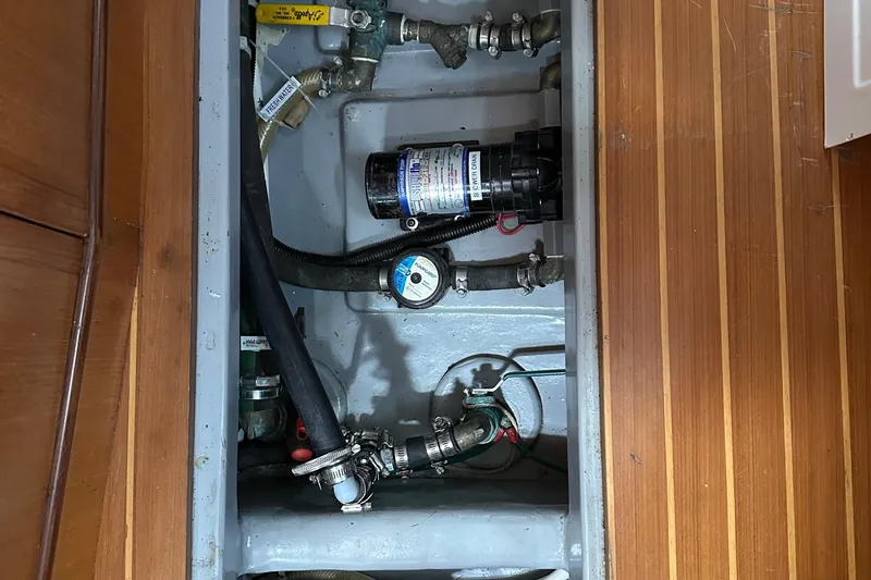 Slide: The Image of Boat plumbing system in a 2006 Passport 470, featuring pipes and a pump. - 63