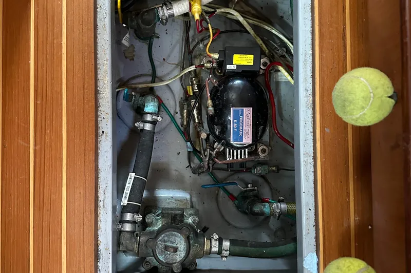 Slide: The Image of Electrical and plumbing components inside a 2006 Passport 470 boat compartment. - 64