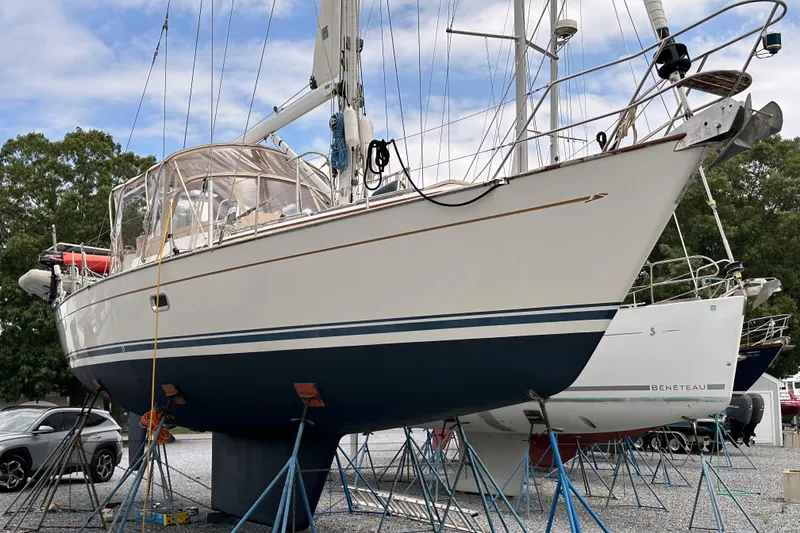 Slide: The Image of 2006 Passport 470 sailboat on stands, with blue and white hull, in a boatyard. - 68