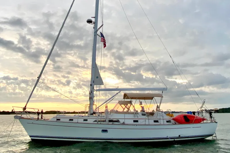 Slide: The Image of Sailboat Passport 470, 2006 model, anchored at sunset with cloudy sky backdrop. - 73