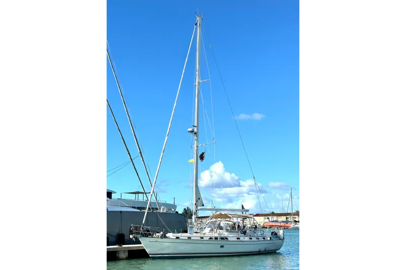 Slide: The Image of Sailboat docked in marina, Passport 470 model, 2006, under clear blue sky. - 74