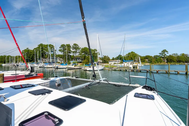 Slide: The Image of 2024 St Francis 460 catamaran docked in a scenic marina with sailboats. - 11