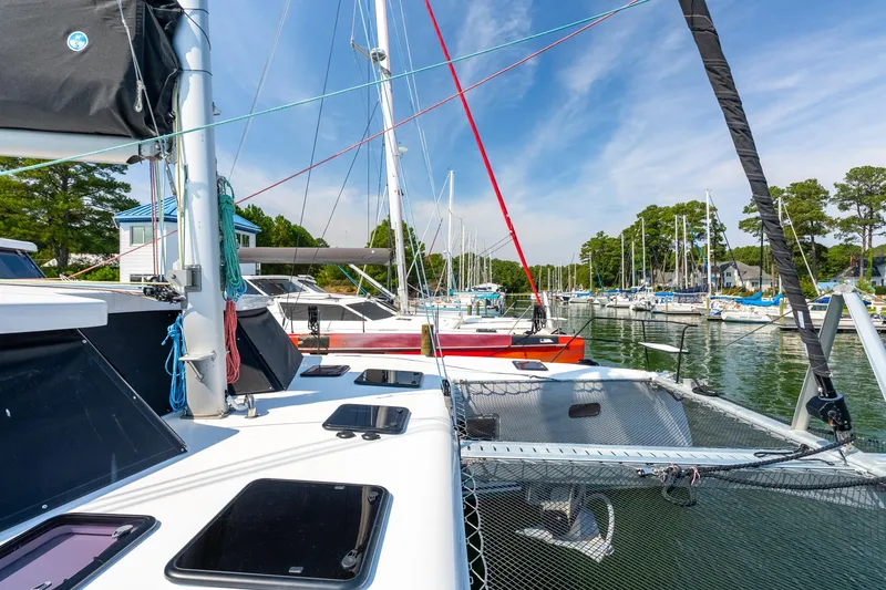 Slide: The Image of 2024 St Francis 460 catamaran docked in a scenic marina with sailboats. - 12